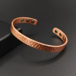 bracelete masculino de cobre - modelo Solluss Forge com acabamento martelado e ímãs magnéticos internos em fundo escuro - Solluss